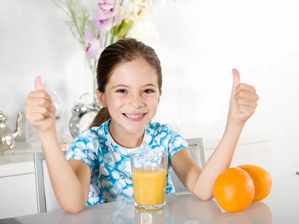 Bambina con il succo d'arancia pollice in su — Foto Stock