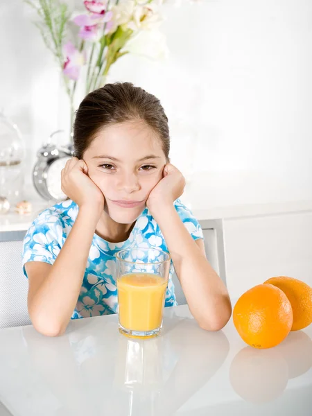Gelangweiltes kleines Mädchen mit Orangensaft — Stockfoto