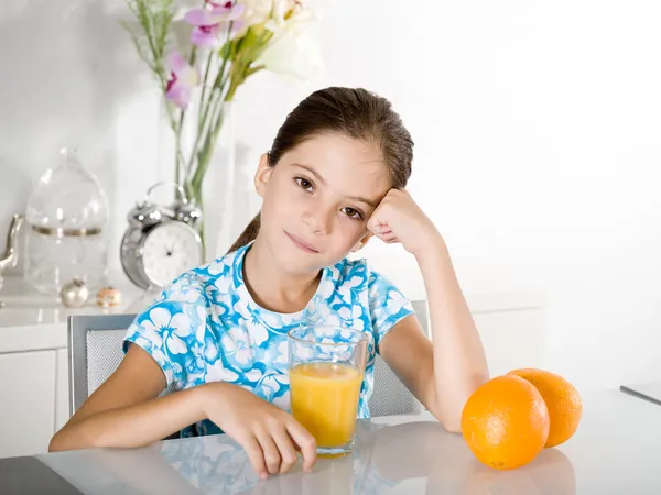 Znuděný holčička s pomerančovým džusem — Stock fotografie