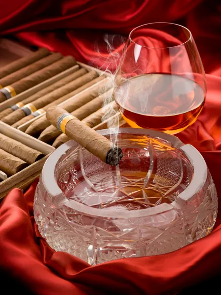 Kubánský doutník a alkohol nad popelníku — Stock fotografie