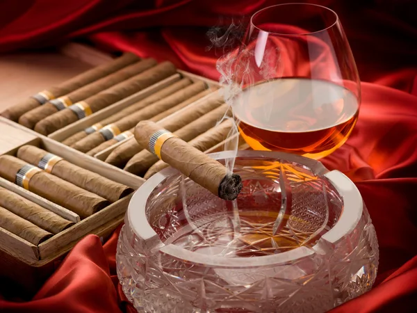 Kubánský doutník a alkohol nad popelníku — Stock fotografie