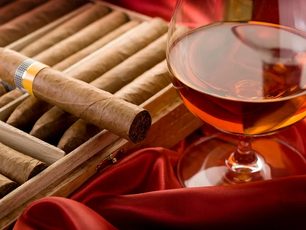 Sigari e liquori cubani su raso rosso — Foto Stock
