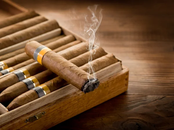 Fumar charuto cubano sobre caixa no fundo de madeira Fotos De Bancos De Imagens