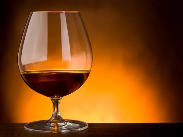 Sklenka alkoholu na dřevěný stůl s copy prostor — Stock fotografie