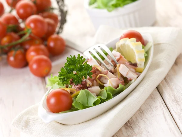 Салат из осьминога с помидорами и салатом — стоковое фото