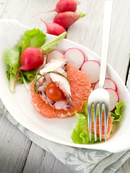 Octopus carpaccio over slice grapefruit with radish and lettuce — Stock Photo, Image