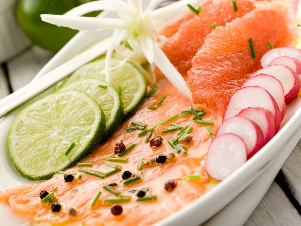 Salmon carpaccio with slice grapefruit, lime and radish — Stock Photo, Image