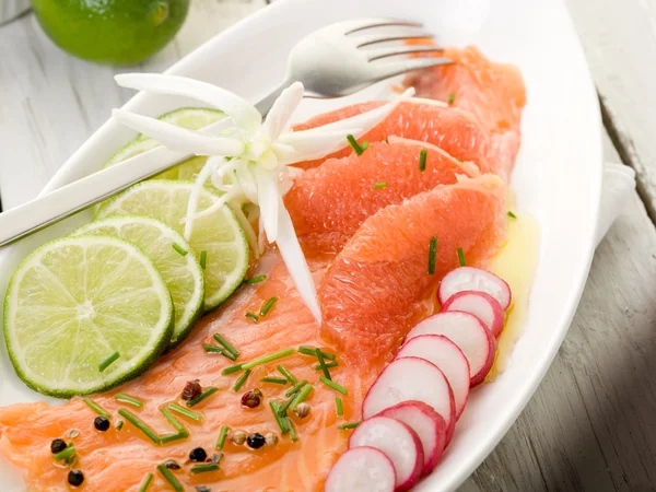 Carpaccio de saumon avec tranches de pamplemousse, citron vert et radis — Photo