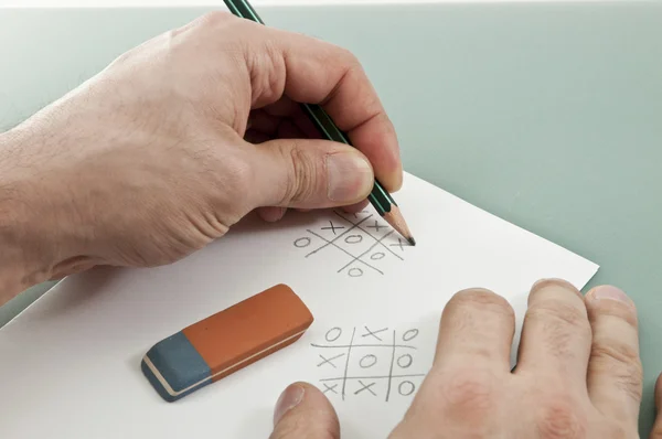Tic tac toe game with left hand writer — Stock Photo, Image