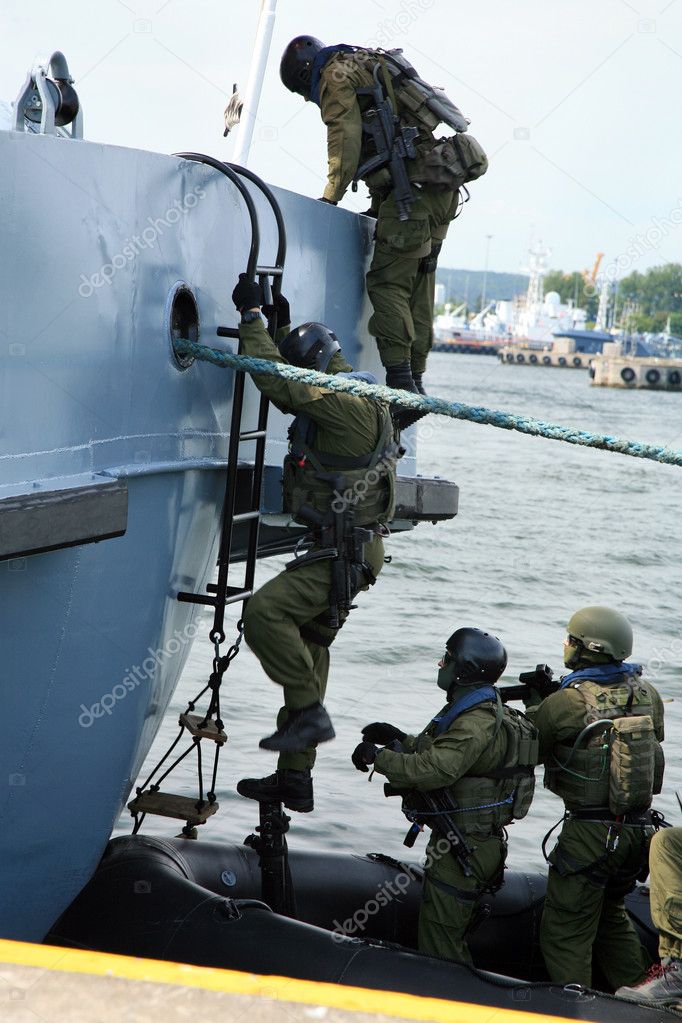 Soldiers marines ( sea commandos ) boarding a ship in a simulated assault.