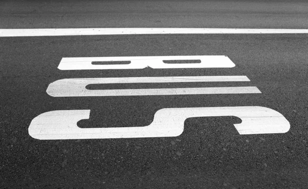 Bus stop sign painted on asphalt road — Stock Photo, Image