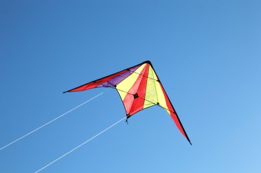 Nice kite flying colors against the blue sky clipart
