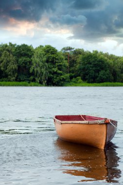 Lone fishing boat floating on the lake clipart