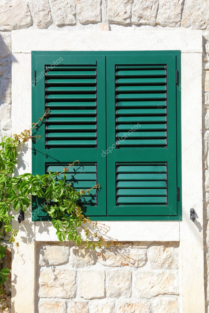 The window with wooden shutters of the old house