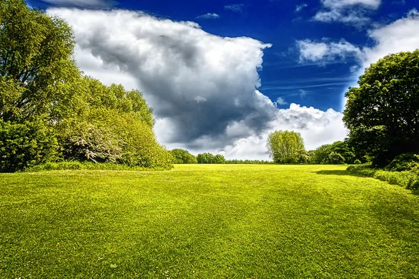 Gröna fält och stormigt moln — Stockfoto