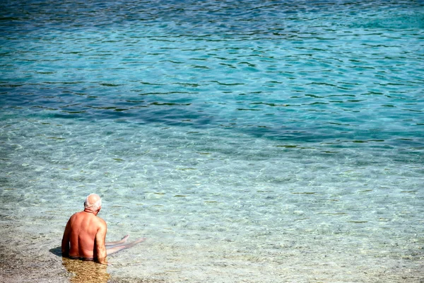 Yaşlı adam sahilde — Stok fotoğraf