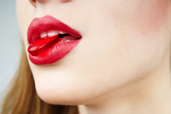 Sexy vrouw met een rode snoep — Stockfoto