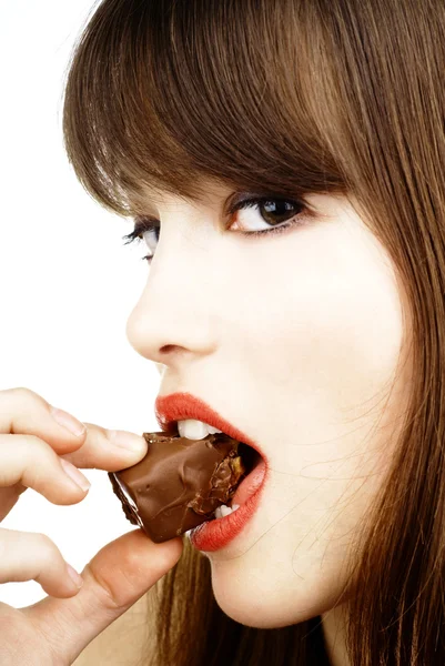 Sexy woman eating a bar of chocolate - studio shot Stock Image