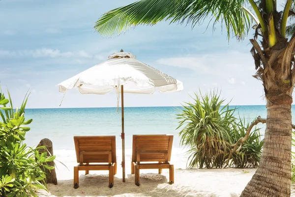 Vista de duas cadeiras e guarda-chuva branco na praia — Fotografia de Stock