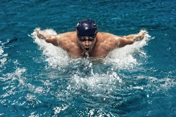 Portret van jonge man zwemmen in zwembad — Stockfoto