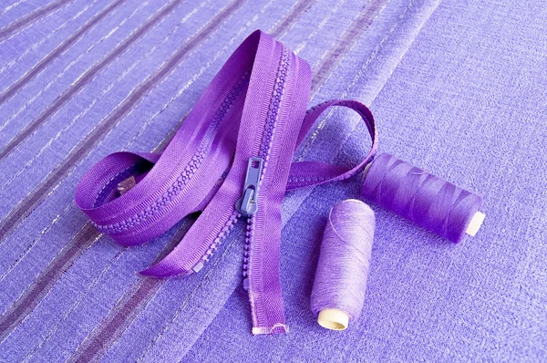 Cierre de cremallera e hilo en la tela púrpura — Foto de Stock