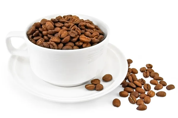 Granos de café en una taza blanca sobre la mesa — Stockfoto