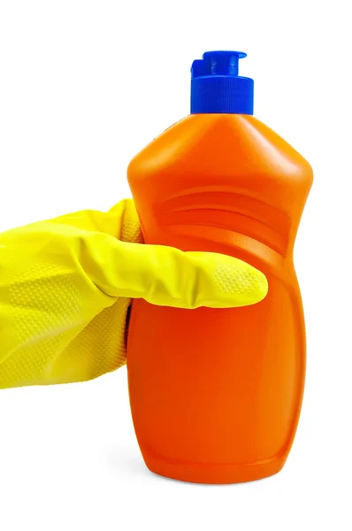 En flaska av orange i gul-handskar handen i den — Stockfoto