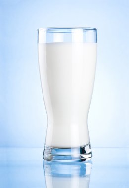 Glass of milk on blue background clipart