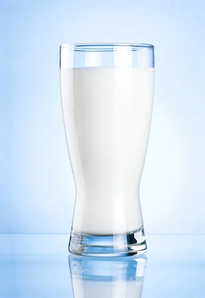 Verre de lait sur fond bleu — Photo