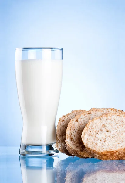 Vaso de leche sobre fondo azul — Foto de Stock