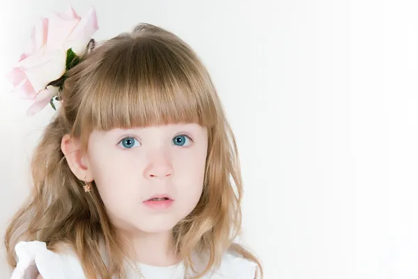 Timid girl with a flower in hair — Stock Photo, Image