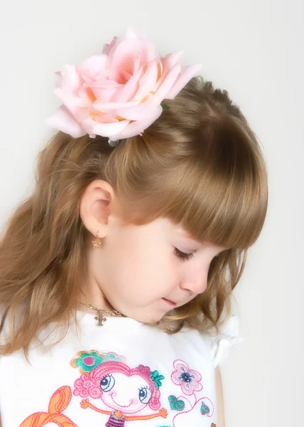 Timid menina com uma flor no cabelo — Fotografia de Stock
