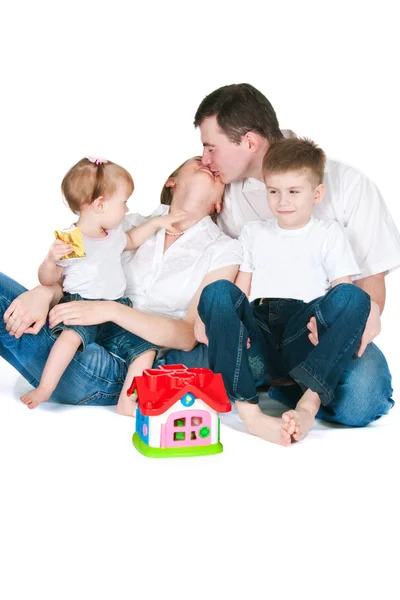 Família feliz perto de uma pequena casa de brinquedo — Fotografia de Stock