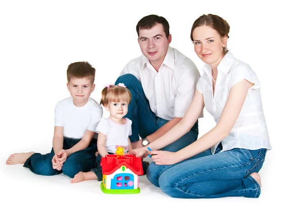 Щаслива сім'я біля іграшкового маленького будинку — стокове фото