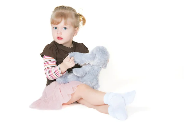 Das kleine Mädchen und das Spielzeugkaninchen — Stockfoto