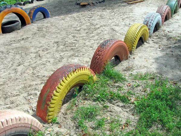 拒绝彩色轮胎堆在沙子上，循环再造的概念. — 图库照片