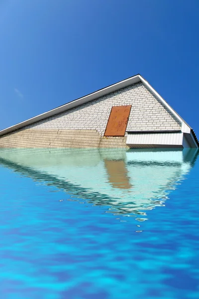 Telhado triângulo de tijolo branco sob a água, céu azul . — Fotografia de Stock