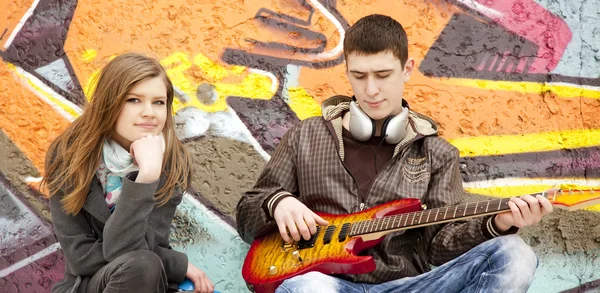 Genç çift gitar, graffiti arka plan ile. — Stok fotoğraf