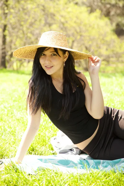 在公园的帽子漂亮的黑发女孩. — 图库照片