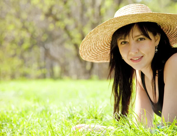 Piękna brunetka dziewczyna w kapeluszu w parku. — Zdjęcie stockowe