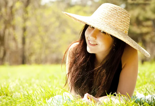 Όμορφη μελαχρινή κοπέλα με το καπέλο στο πάρκο. — Φωτογραφία Αρχείου