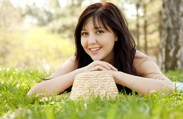 Beautiful brunette girl with hat at the park. — Stock Photo, Image