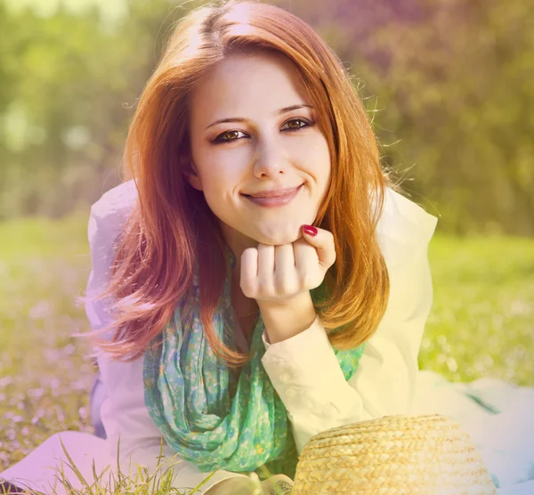 Rusovláska dívka na trávě v parku. Foto v vícebarevná stylu. — Stock fotografie