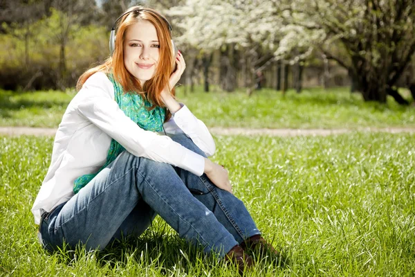 Redhead girl with headphone in the park. — Stock Photo, Image