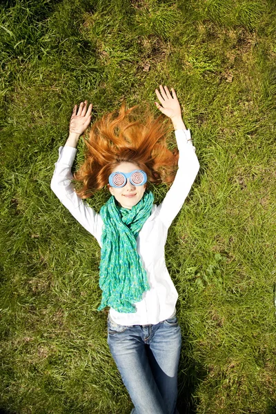 Mädchen liegt auf grünem Gras im Park. — Stockfoto