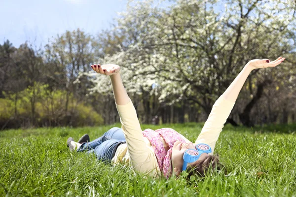 Menina morena em óculos engraçados fica no prado . — Fotografia de Stock