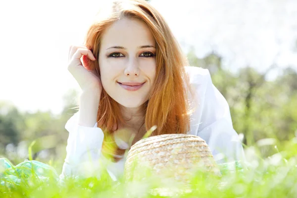 Krásná rusovlasá dívka s kloboukem v parku. — Stock fotografie