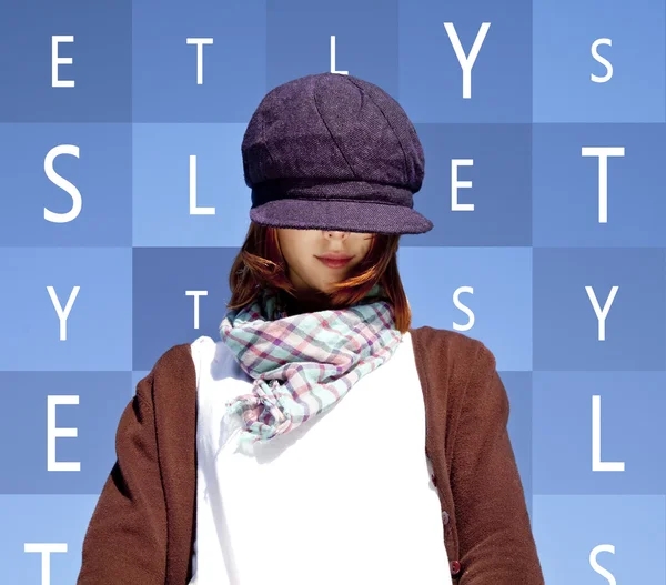Portrait of red-haired girl with scarf and purple cap on blue ba — Stock Photo, Image