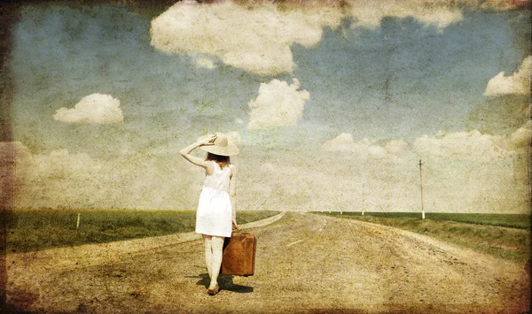 Chica solitaria con maleta en el camino del campo . — Foto de Stock