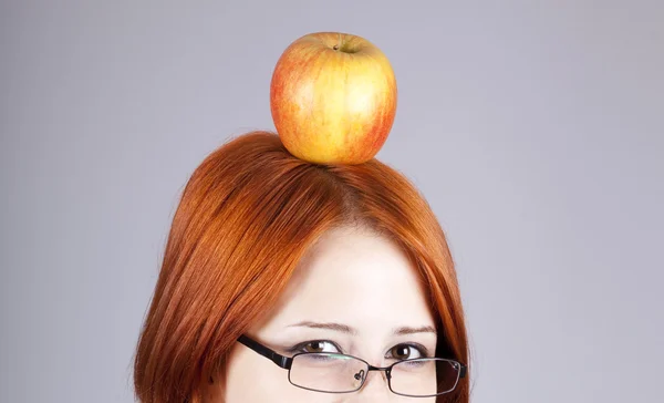 Redhead girl keep apple on her head. — Stock Photo, Image